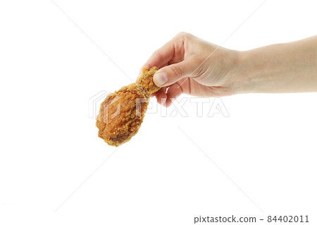 Female hand holds fried chicken, isolated on white background Female hand holds fried chicken, isolated on white background 84402011