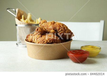 Concept of tasty eating with fried chicken on white textured table Concept of tasty eating with fried chicken on white textured table 84402014