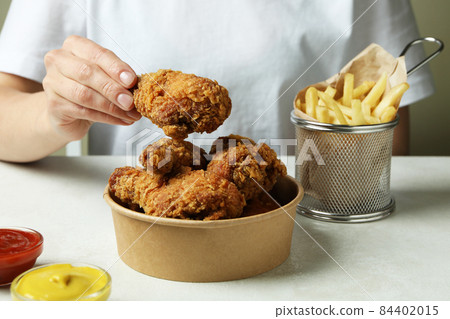Concept of tasty eating with fried chicken on white textured table Concept of tasty eating with fried chicken on white textured table 84402015