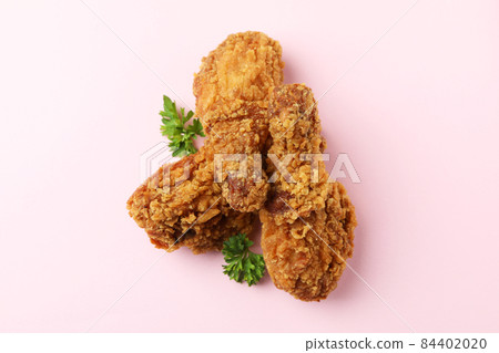 Tasty fried chicken on pink background, close up 84402020