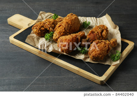 Concept of tasty eating with fried chicken on dark wooden background 84402040