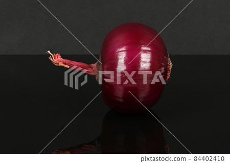 Red onion bulb isolated on acrylic black background. Red onion bulb isolated on acrylic black background. 84402410