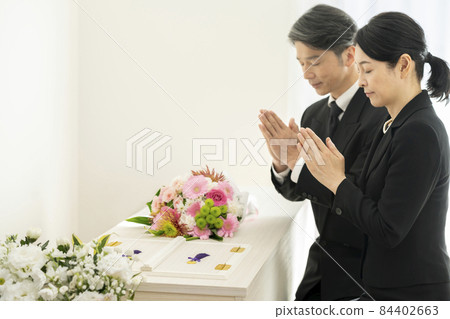 身著喪服的男女在棺材前手牽手 84402663