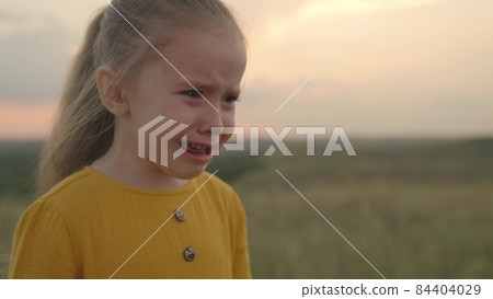 a little upset child is crying at sunset, tears are flowing down the kid's face, an expression of discontent emotion, cry of stress from the soul, girl does not want to obey, child problem wet face a little upset child is crying at sunset, tears are flowing down the kid's face, an expression of discontent emotion, cry of stress from the soul, girl does not want to obey, child problem wet face 84404029
