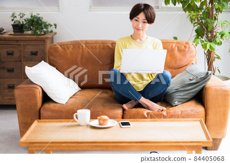 一個女人在沙發上操作電腦 84405068