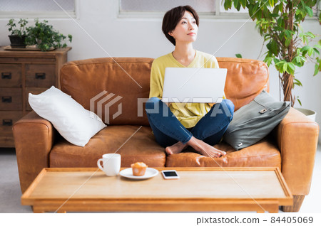 一個女人在沙發上操作電腦 84405069