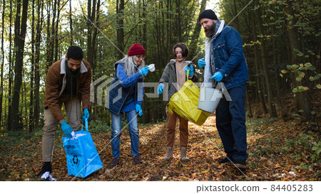 Diverse group of happy volunteers cleaning up forest from waste, community service concept. 84405283