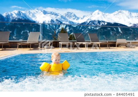 Child in outdoor swimming pool of alpine resort Child in outdoor swimming pool of alpine resort 84405491