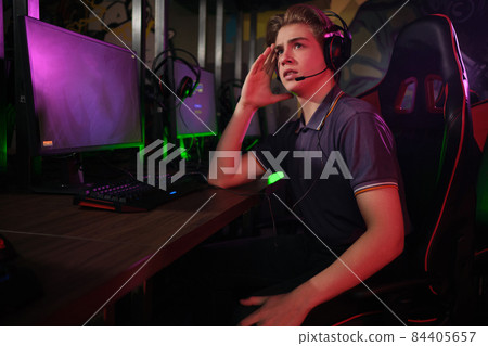 Professional young caucasian gamer playing online on his PC. He upset because of losing the game Professional young caucasian gamer playing online on his PC. He upset because of losing the game 84405657