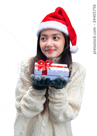 Asian woman with winter gloves and Santa hat holding white gift box Asian woman with winter gloves and Santa hat holding white gift box 84405756
