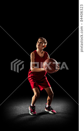 Portrait of concentrated basketball team player, sportsman training isolated over black background 84406323
