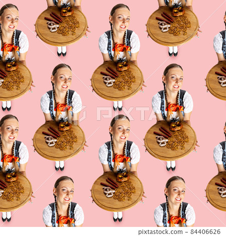 Pattern, Elevated view Oktoberfest woman, waitress wearing a traditional Bavarian costume isolated on pink studio background. 84406626