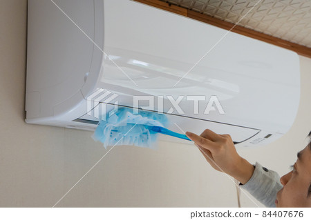 A man cleaning the air conditioner A man cleaning the air conditioner 84407676