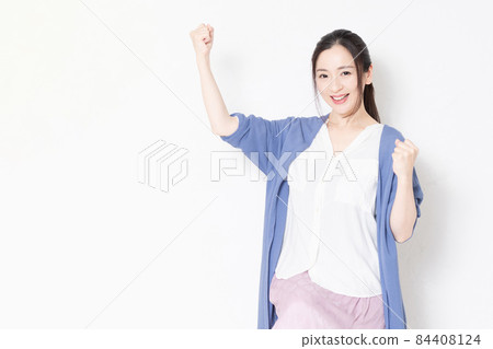家庭主婦坐在白牆前的椅子上,擺出勇敢的姿勢 家庭主婦坐在白牆前的椅子上,擺出勇敢的姿勢 84408124