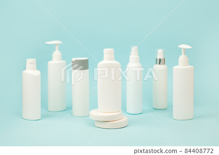 Set of white cosmetic bottles with soft shadows on light blue background. Home and beauty salon care concept, mock up, copy space, beauty industry banner, flyer, coupon, selective focus Set of white cosmetic bottles with soft shadows on light blue background. Home and beauty salon care concept, mock up, copy space, beauty industry banner, flyer, coupon, selective focus 84408772