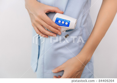 Temperature measurement gun in doctor hands. Close-up shot of doctor wearing protective surgical mask ready to use infrared isometric thermometer gun to check body temperature for virus symptoms. Temperature measurement gun in doctor hands. Close-up shot of doctor wearing protective surgical mask ready to use infrared isometric thermometer gun to check body temperature for virus symptoms. 84409264
