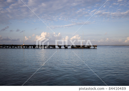 The morning seascape. The pier, the sea and soft clouds above it. The morning seascape. The pier, the sea and soft clouds above it. 84410489