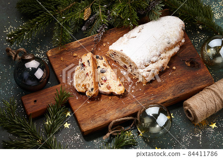 Sliced Christmas stollen cake on wooden board Sliced Christmas stollen cake on wooden board 84411786