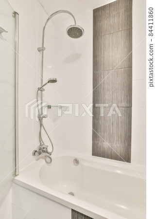 Beautiful bathroom with a big bathtub and white walls Beautiful bathroom with a big bathtub and white walls 84411860