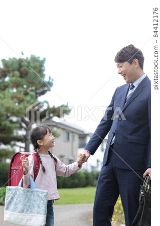 Elementary school girl and dad going to and from school together Elementary school girl and dad going to and from school together 84412176