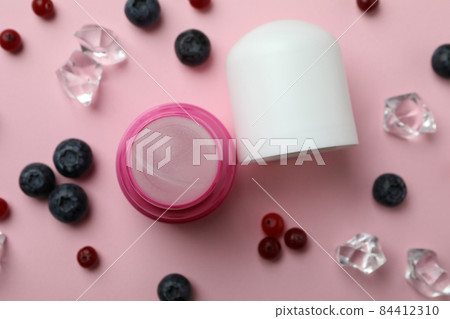 Roll-on deodorant, ice cubes and berries on pink background Roll-on deodorant, ice cubes and berries on pink background 84412310