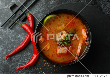 Concept of tasty eating with Tom yum soup on black smokey background 84412374