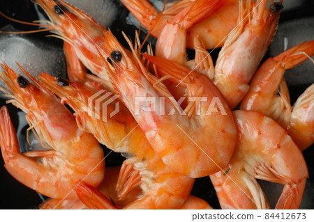 Tasty cooked shrimps and ice cubes, close up Tasty cooked shrimps and ice cubes, close up 84412673