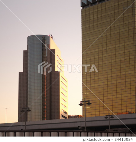 Office buildings illuminated by dusk, cityscape at sunset, skyscrapers illuminated by sunset 84413084