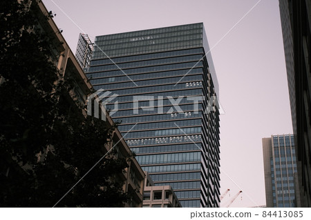 Office buildings illuminated by dusk, cityscape at sunset, skyscrapers illuminated by sunset 84413085