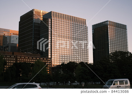 Office buildings illuminated by dusk, cityscape at sunset, skyscrapers illuminated by sunset 84413086