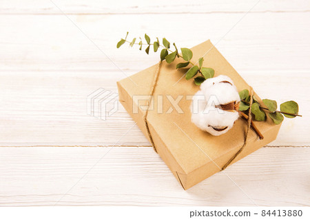 Christmas mood concept. Flat lay composition with presents wrapped in craft paper and tied with baker's twine string, dried orange slices and other festive attributes. Close up, copy space, background Christmas mood concept. Flat lay composition with presents wrapped in craft paper and tied with baker's twine string, dried orange slices and other festive attributes. Close up, copy space, background 84413880
