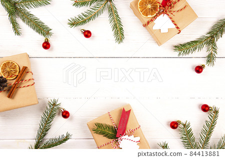 Christmas mood concept. Flat lay composition with presents wrapped in craft paper and tied with baker's twine string, dried orange slices and other festive attributes. Close up, copy space, background 84413881
