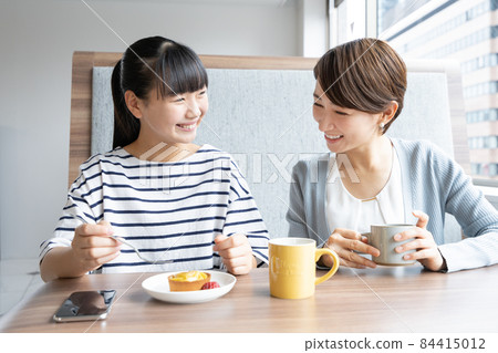 Mother and daughter eating dessert at a family restaurant 84415012