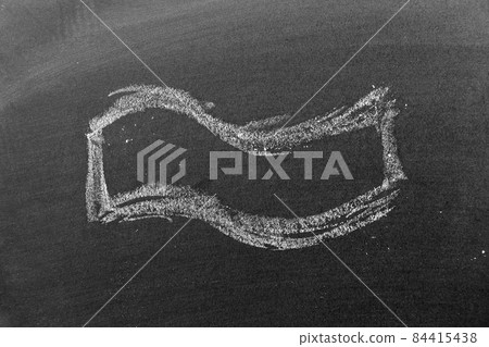 White color chalk hand drawing in wavy banner shape on black board background White color chalk hand drawing in wavy banner shape on black board background 84415438