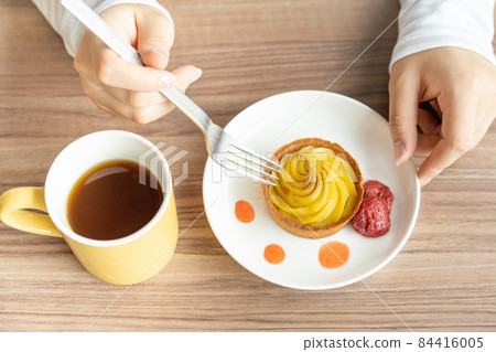 Up at hand of a girl trying to eat tart Up at hand of a girl trying to eat tart 84416005