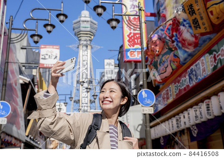 Tsutenkaku Shinsekai, a woman sightseeing in Osaka Tsutenkaku Shinsekai, a woman sightseeing in Osaka 84416508