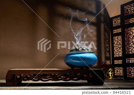 Smoke from burning incense sticks standing on lotus incense holder Smoke from burning incense sticks standing on lotus incense holder 84416521