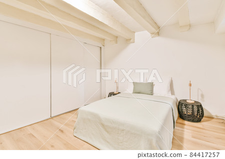 Luxurious bedroom and a single bed with a gentle green bedspread 84417257