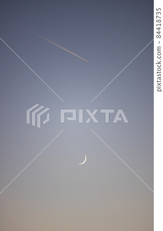 Crescent moon, contrails and magic hour 84418735