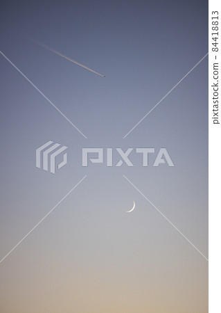 Twilight, crescent moon and contrails 84418813