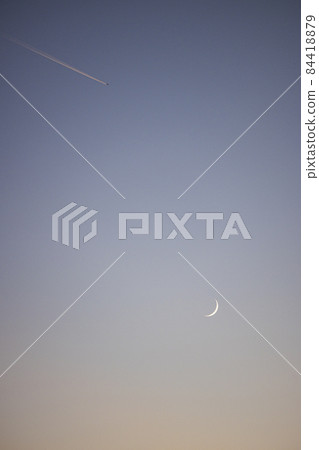 Crescent moon and contrails at dusk 84418879