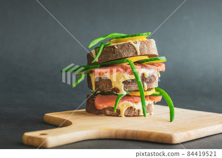 Sandwiches with red fish, cucumber and lemon on a wooden stand Sandwiches with red fish, cucumber and lemon on a wooden stand 84419521