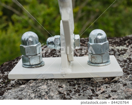 Detail of zinc coated cup head nuts screwed on screw anchors Detail of zinc coated cup head nuts screwed on screw anchors 84420764