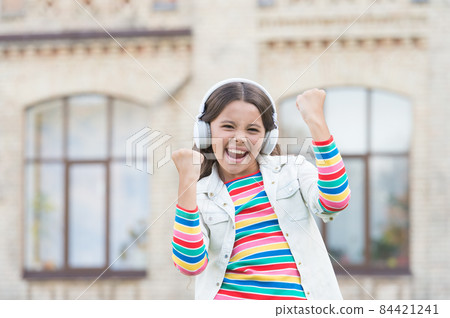 Happy energetic girl listening music modern headphones, joy and happiness concept Happy energetic girl listening music modern headphones, joy and happiness concept 84421241