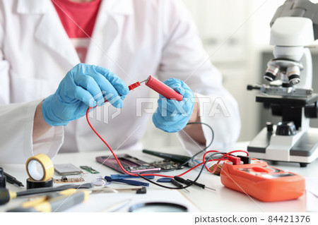 Master repairman checking battery charge using tester closeup 84421376