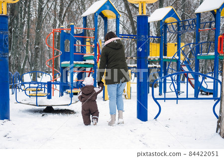 Best Outdoor Winter Activities with Baby. Baby toddler in Winter, How to Protect kids in Cold Weather. Mother and baby girl daughter walking in the winter park Best Outdoor Winter Activities with Baby. Baby toddler in Winter, How to Protect kids in Cold Weather. Mother and baby girl daughter walking in the winter park 84422051