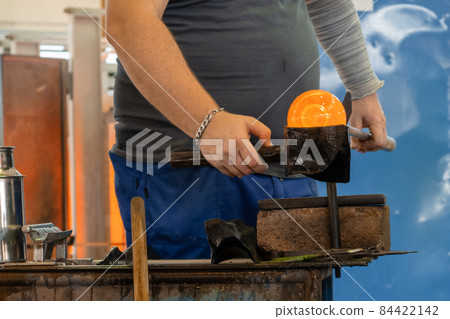 Manual glass production by glassblowing by worker at the factory. Manual glass production by glassblowing by worker at the factory. 84422142