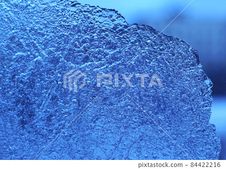 Macro of natural blue ice on glass background Macro of natural blue ice on glass background 84422216