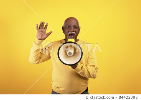 Positive senior African American man with megaphone sharing news, proclaiming something on orange studio background 84422398
