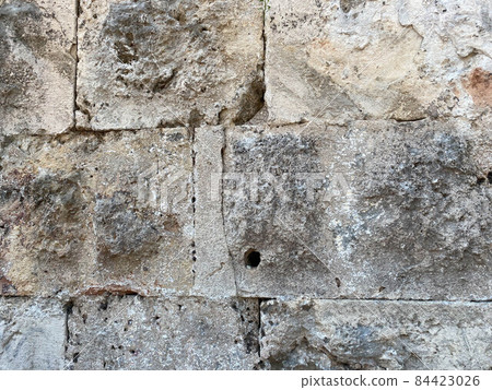 A fragment of a stone wall made of roughly hewn stone A fragment of a stone wall made of roughly hewn stone 84423026